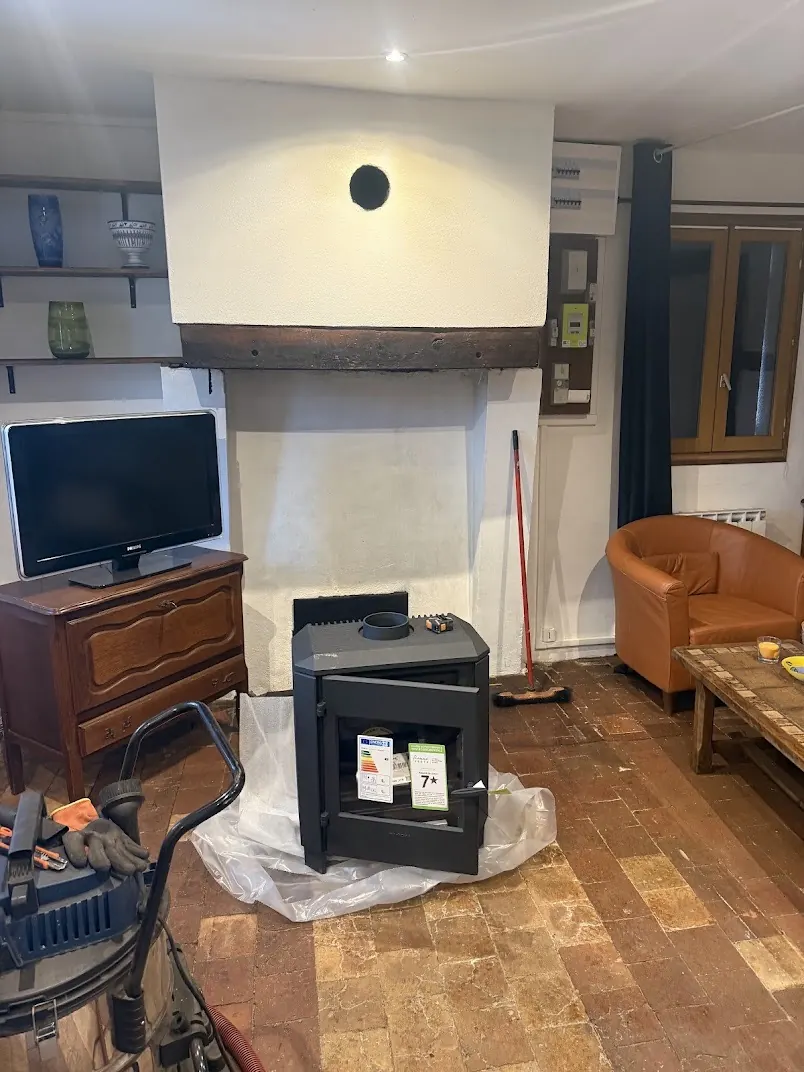 Poêle à bois en cours d'installation dans une cheminée existante à Montargis